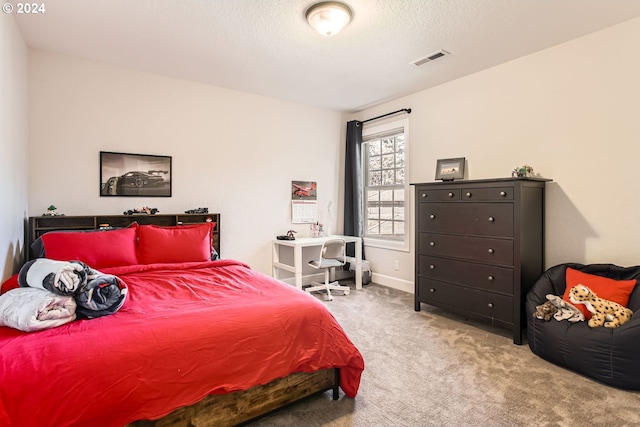 bedroom featuring light colored carpet and a textured ceiling