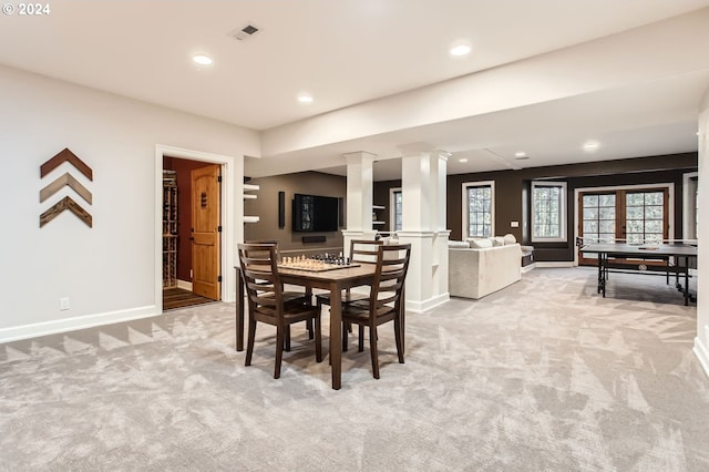 dining space with french doors, light colored carpet, and ornate columns