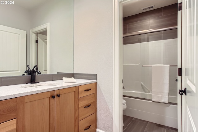 full bathroom with vanity, enclosed tub / shower combo, and toilet