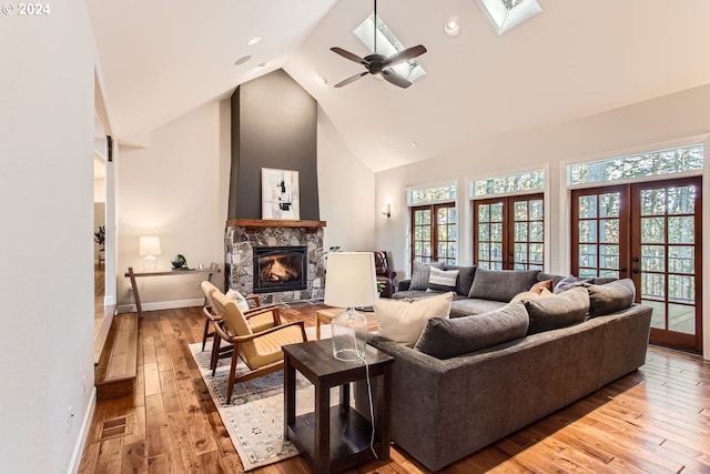 13516 NW Glendoveer Dr, Portland, OR 97231 - living area featuring high vaulted ceiling, a stone fireplace, baseboards, wood-type flooring, and french doors
