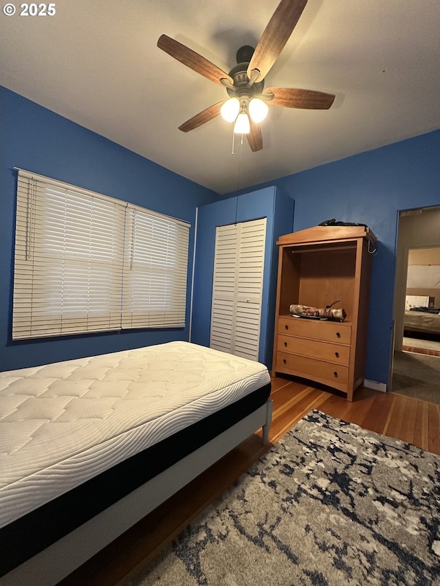 bedroom with ceiling fan, a closet, and hardwood / wood-style flooring