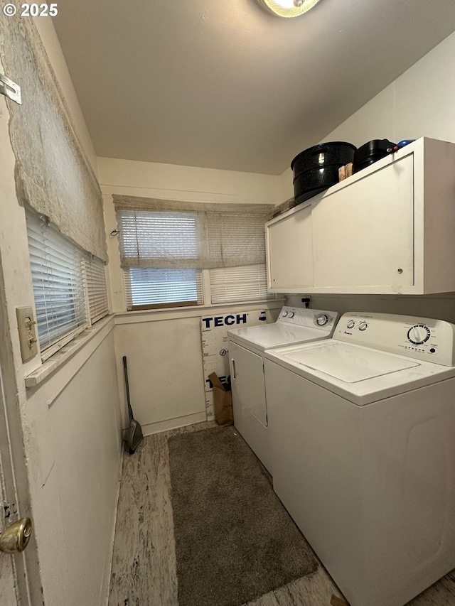 clothes washing area featuring cabinets and washing machine and dryer