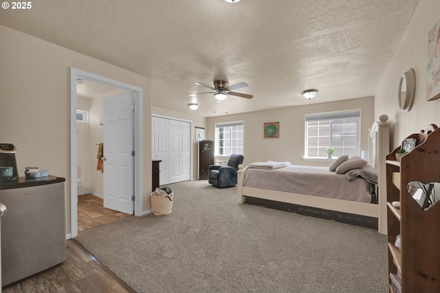 87973 Sherwood St, Veneta, OR 97487 - bedroom with a textured ceiling, dark wood-style floors, baseboards, a closet, and connected bathroom