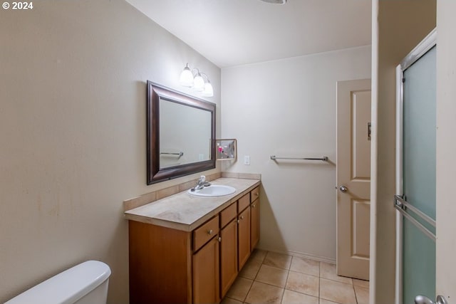 bathroom featuring vanity, toilet, an enclosed shower, and tile patterned flooring