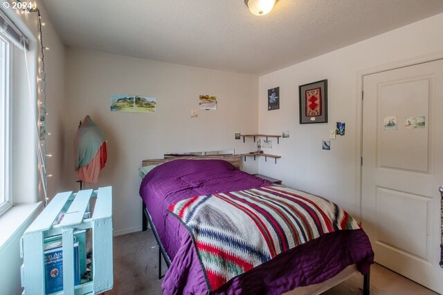 carpeted bedroom featuring a textured ceiling