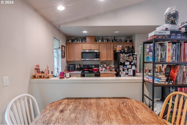 kitchen with black fridge, wood counters, electric stove, and vaulted ceiling