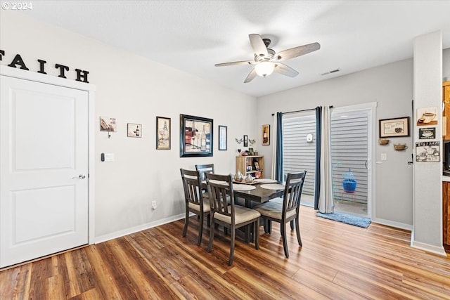 dining area featuring wood-type flooring and ceiling fan