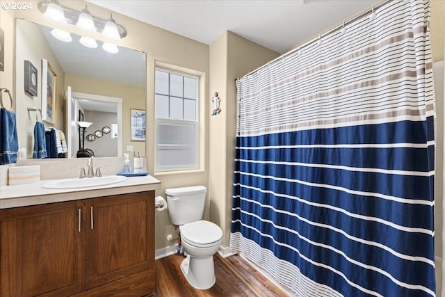 bathroom with hardwood / wood-style flooring, vanity, and toilet