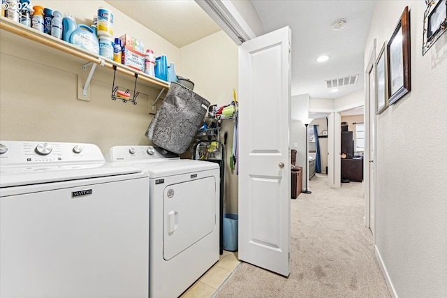 laundry room featuring light carpet and washer and dryer