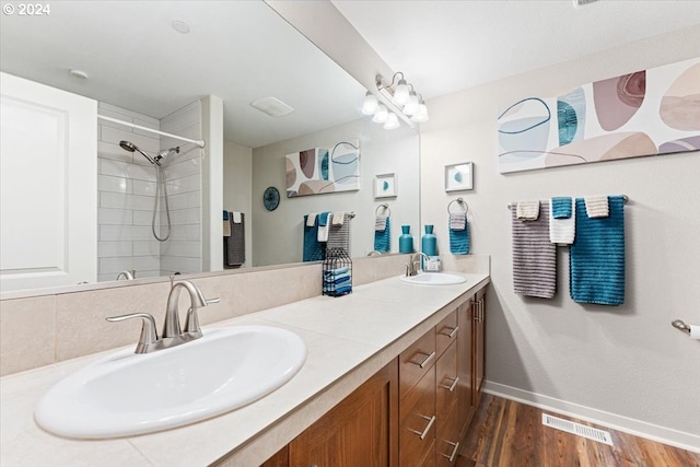 bathroom with vanity, hardwood / wood-style flooring, and a tile shower