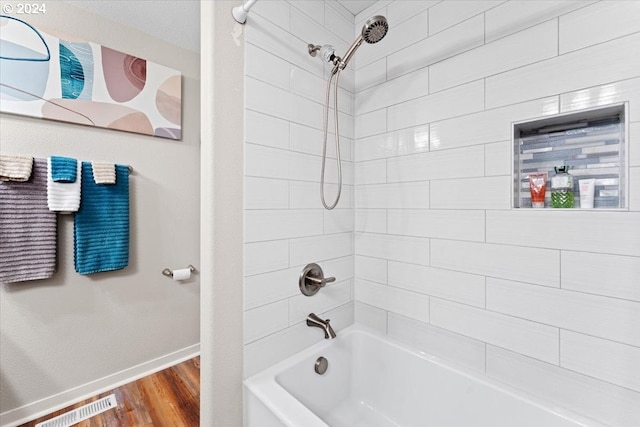 bathroom featuring hardwood / wood-style floors and tiled shower / bath