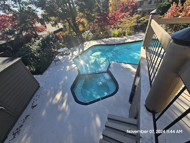 view of pool with an in ground hot tub