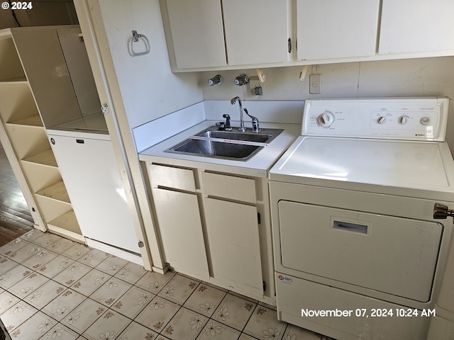 laundry room featuring cabinets, washer / dryer, light wood-type flooring, and sink