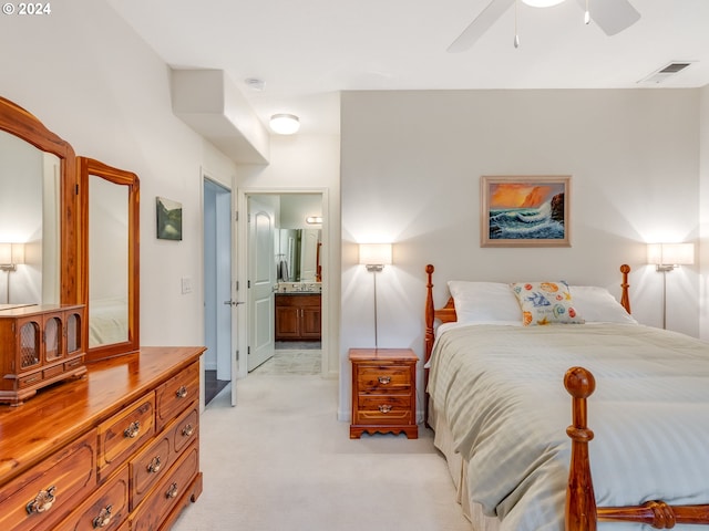 bedroom featuring ceiling fan, light colored carpet, and ensuite bathroom