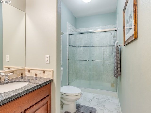 bathroom with vanity, toilet, and a shower with door