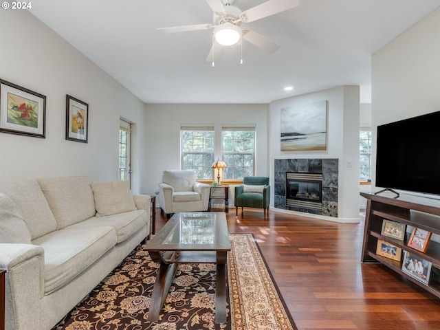 living room with dark hardwood / wood-style flooring, ceiling fan, and a fireplace