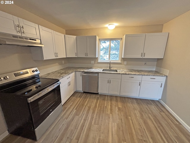 kitchen with light hardwood / wood-style floors, white cabinetry, and appliances with stainless steel finishes