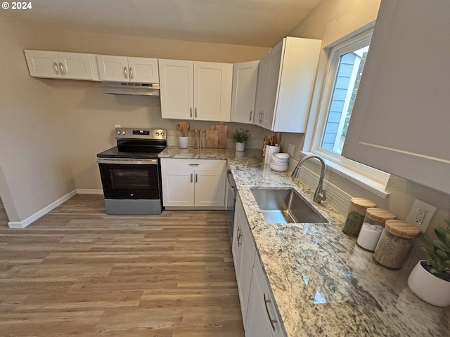 kitchen with appliances with stainless steel finishes, light wood-type flooring, light stone counters, sink, and white cabinetry