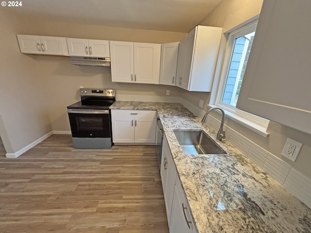 kitchen with light stone counters, stainless steel appliances, sink, light hardwood / wood-style flooring, and white cabinets