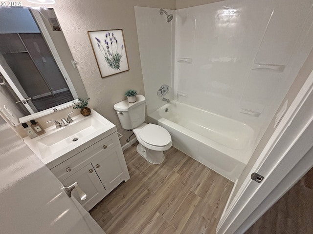 full bathroom with washtub / shower combination, hardwood / wood-style floors, vanity, and toilet