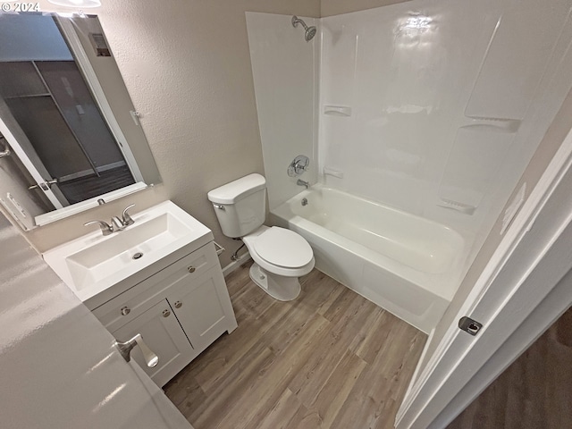 full bathroom featuring hardwood / wood-style floors, vanity, toilet, and tub / shower combination