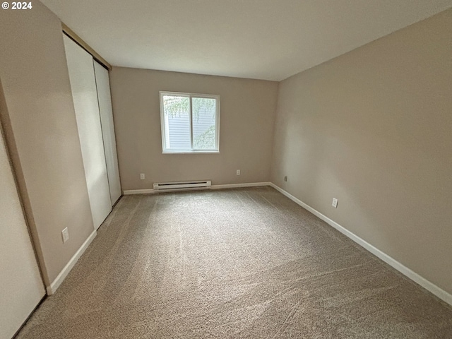 spare room featuring baseboard heating and carpet flooring