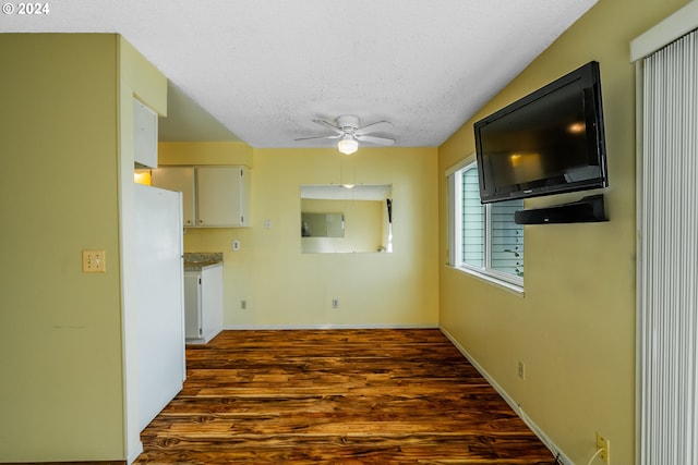 interior space with white cabinetry, ceiling fan, a textured ceiling, and dark hardwood / wood-style floors