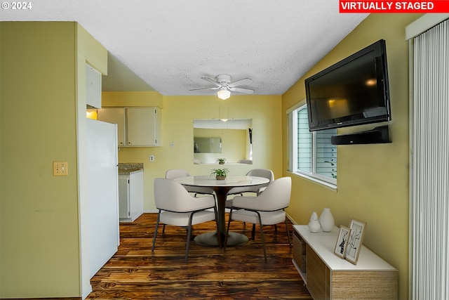 dining room featuring dark wood-type flooring, ceiling fan, a textured ceiling, and lofted ceiling