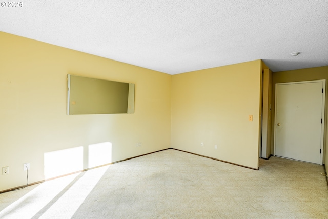 carpeted spare room featuring a textured ceiling