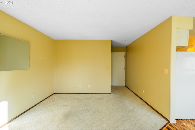 carpeted empty room with a textured ceiling