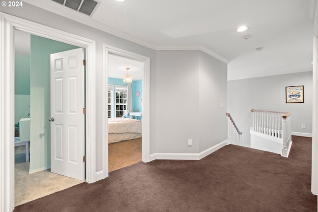 hall with dark carpet and ornamental molding