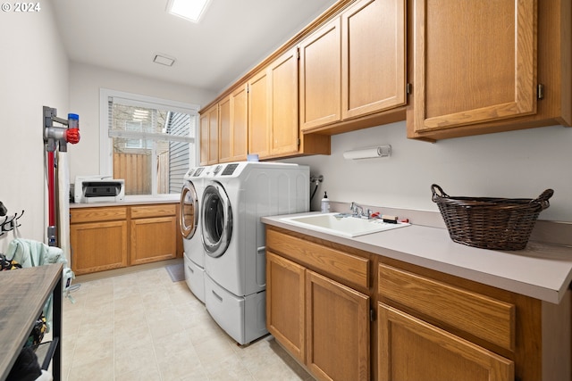 laundry area featuring cabinets, washing machine and dryer, and sink