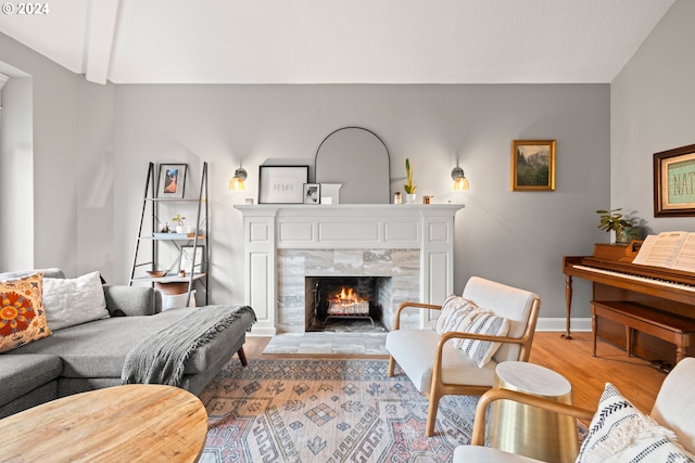 living room featuring light wood-type flooring and a tiled fireplace