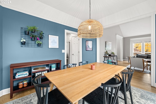 dining space featuring a notable chandelier, wood-type flooring, and lofted ceiling