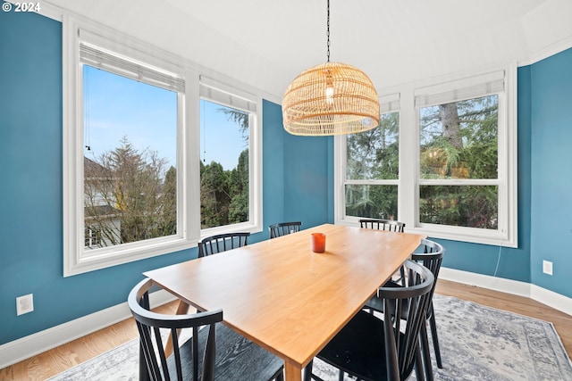 dining space with hardwood / wood-style floors and an inviting chandelier