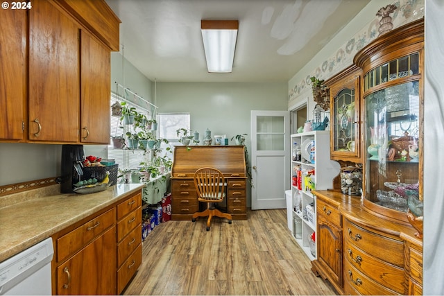 30274 Peoria Rd, Shedd, OR 97377 - kitchen with white dishwasher, light wood-style flooring, brown cabinets, light countertops, and glass insert cabinets