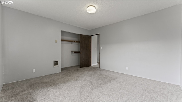 976 E St, Coos Bay, OR 97420 - unfurnished bedroom with heating unit, carpet, a closet, and a textured ceiling