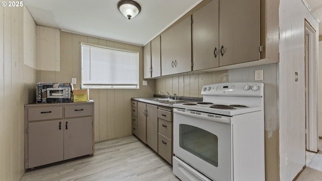 976 E St, Coos Bay, OR 97420 - kitchen featuring white range with electric stovetop, a sink, and light wood-type flooring