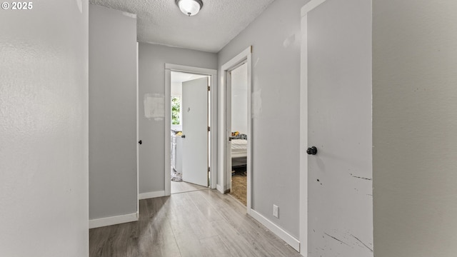 976 E St, Coos Bay, OR 97420 - hall with wood finished floors, a textured ceiling, and baseboards