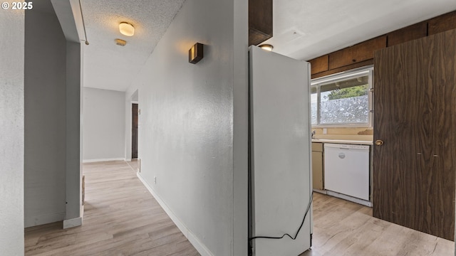 976 E St, Coos Bay, OR 97420 - hall with light wood-style flooring, baseboards, and a textured ceiling