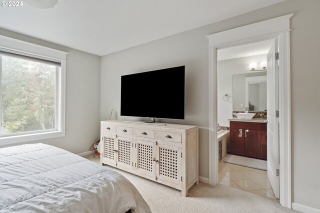 bedroom with sink, light carpet, and ensuite bathroom