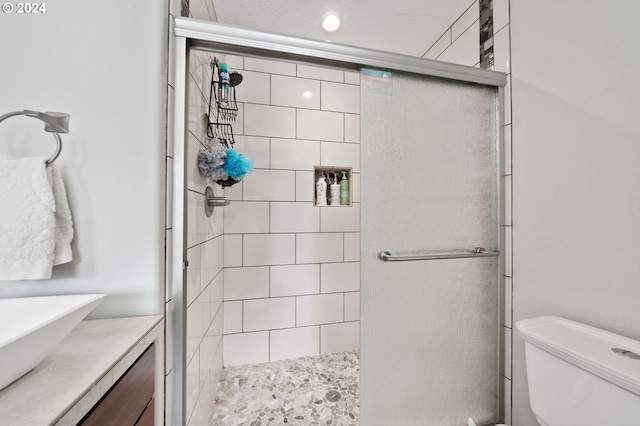 bathroom featuring vanity, toilet, and a shower with shower door