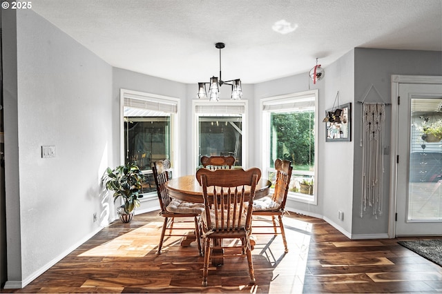 dining space with a textured ceiling, baseboards, and dark wood-style flooring