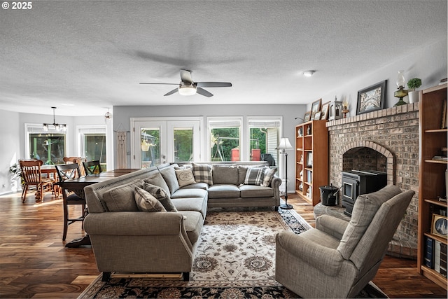 living room with dark wood-style floors, french doors, a textured ceiling, and ceiling fan with notable chandelier