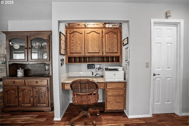 office with built in desk, dark hardwood / wood-style flooring, and a textured ceiling