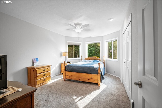 carpeted bedroom featuring ceiling fan and a closet