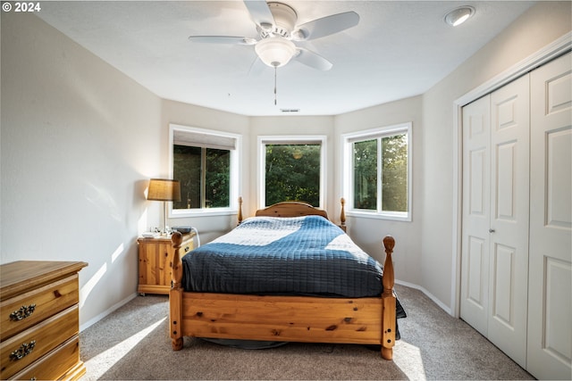 carpeted bedroom with ceiling fan and a closet