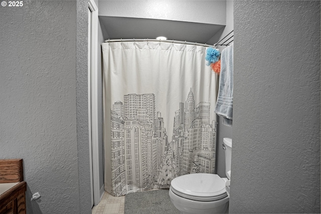 bathroom featuring toilet, a shower with curtain, and a textured wall