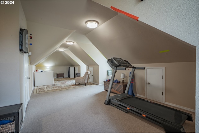 workout area with carpet flooring and vaulted ceiling