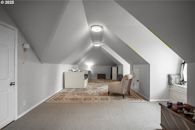 carpeted bedroom with lofted ceiling and baseboards